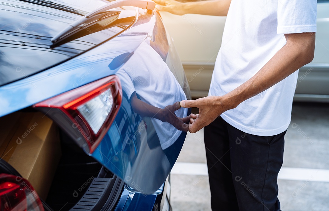 Homem abrindo porta mala de carro