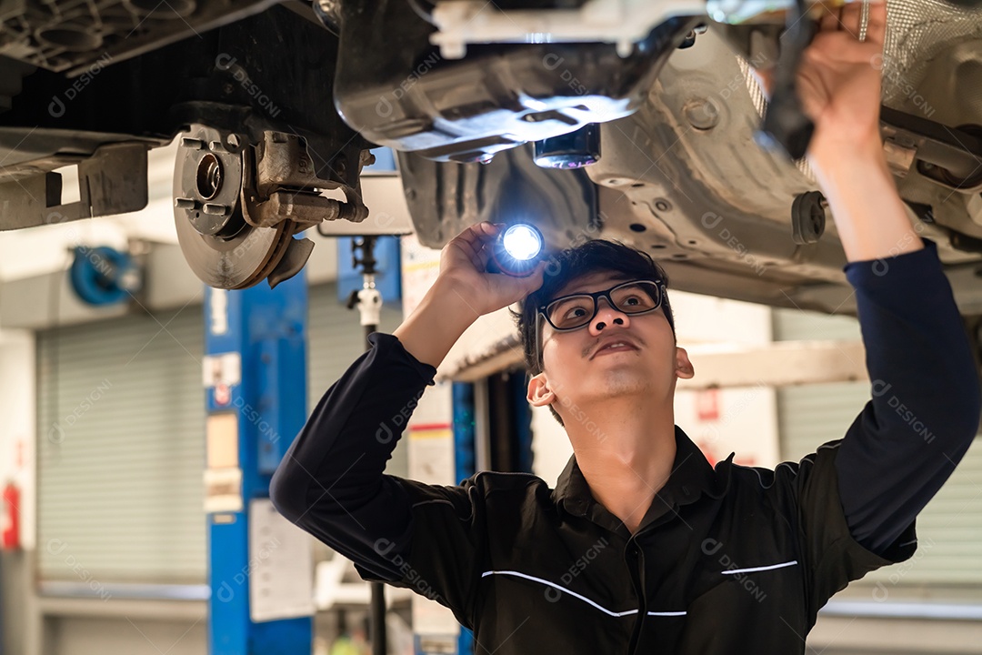 Homem asiático mecânico examinando carro