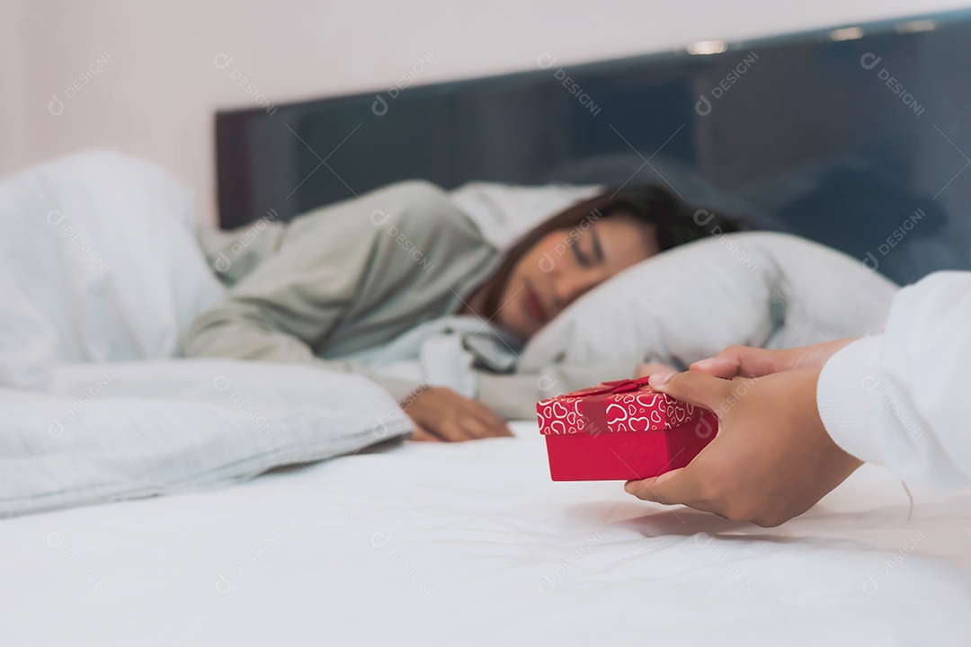 A filha adolescente está colocando uma caixa de presente na cama