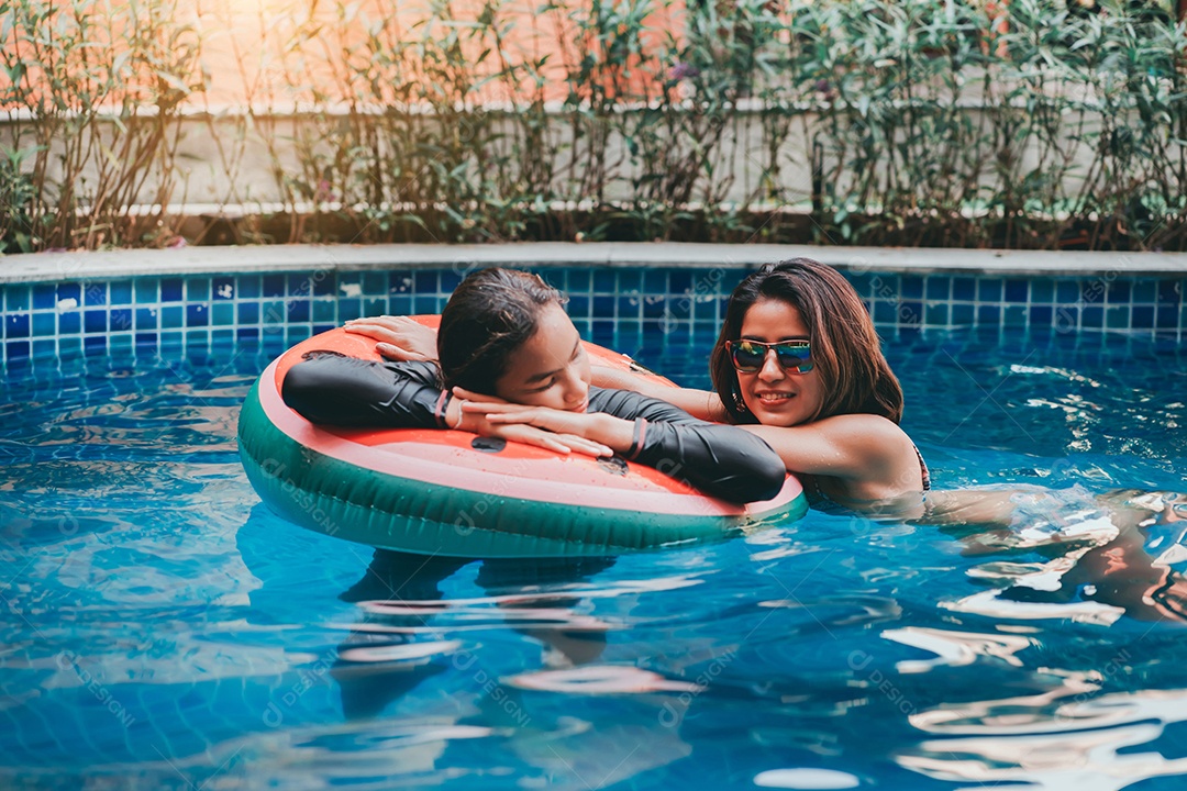 Mãe e filha adolescente nadando juntas relaxam com boia