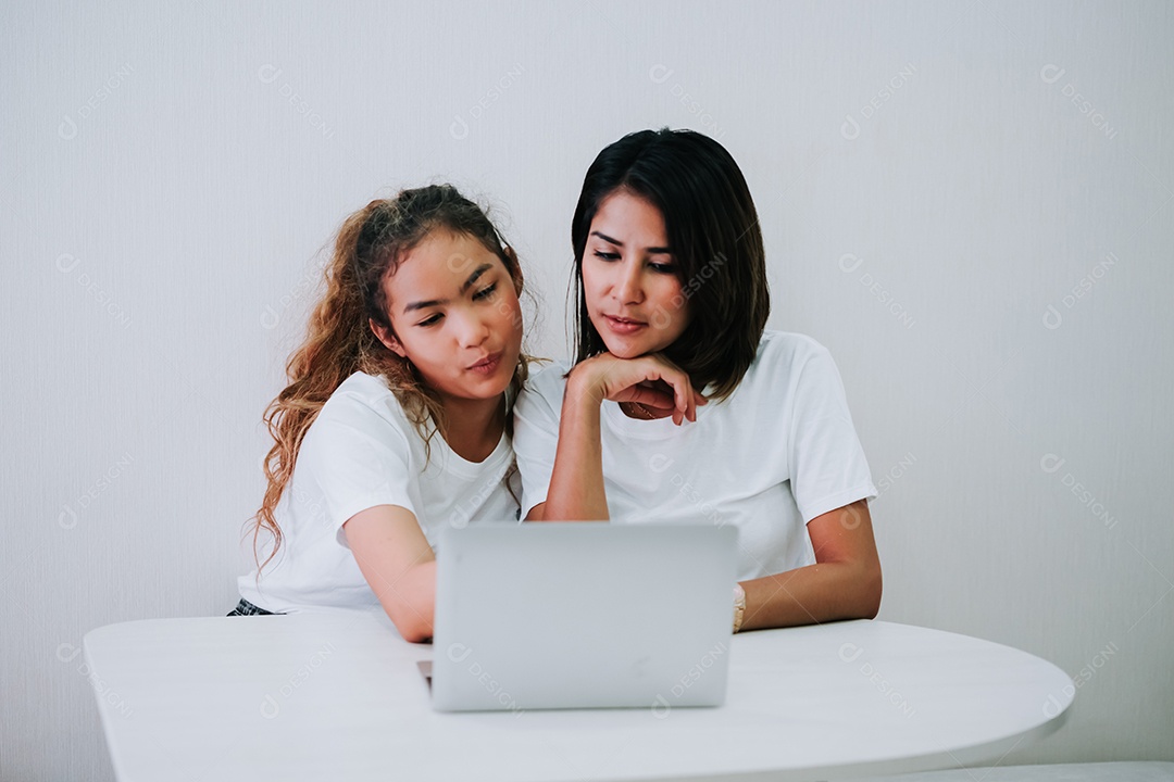 Mãe de família feliz e filha adolescente usando computador portátil