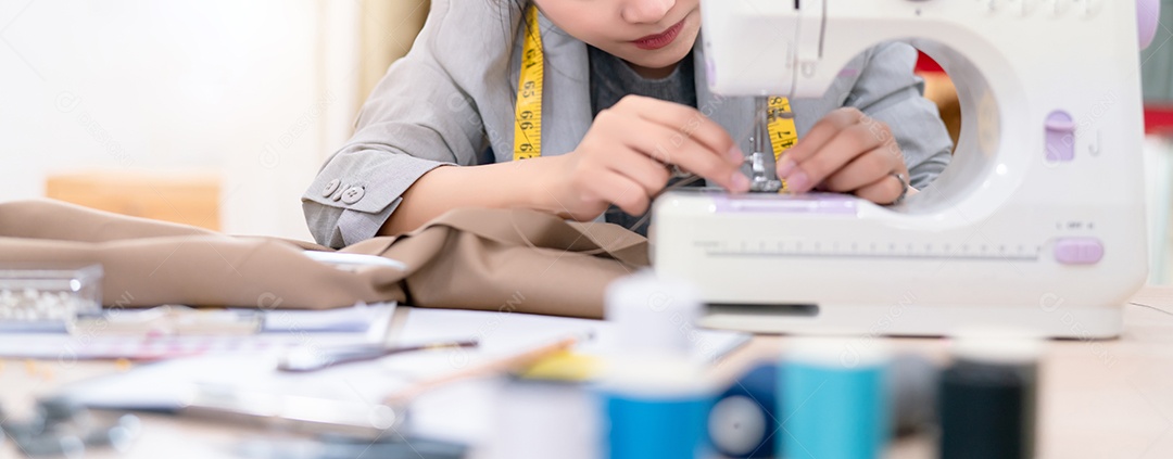 Linda mulher asiática estilista de tecido sob medida trabalhando e costurando