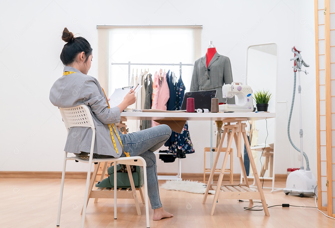 Estilista de moda asiática trabalhando e costurando