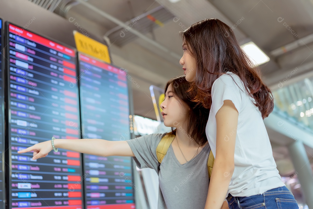 Jovem asiática junto viajante olhando horário do transporte