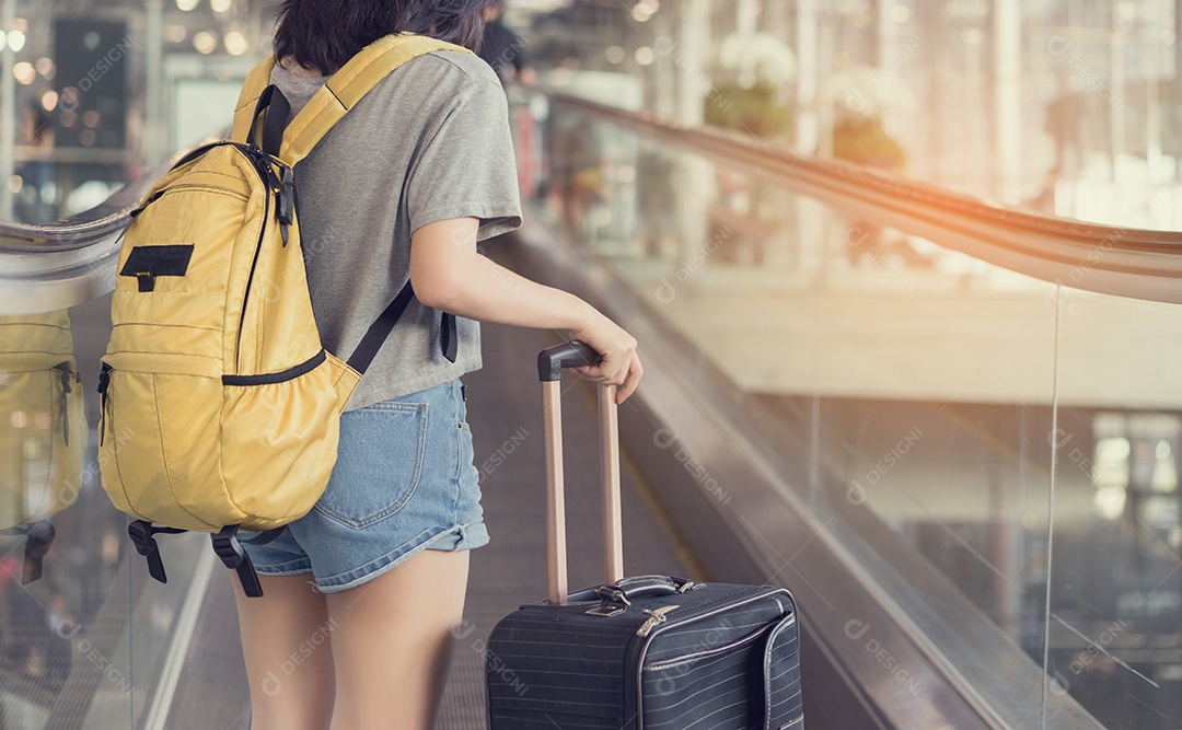 Jovem viajante asiática andando com bagagem no aeroporto