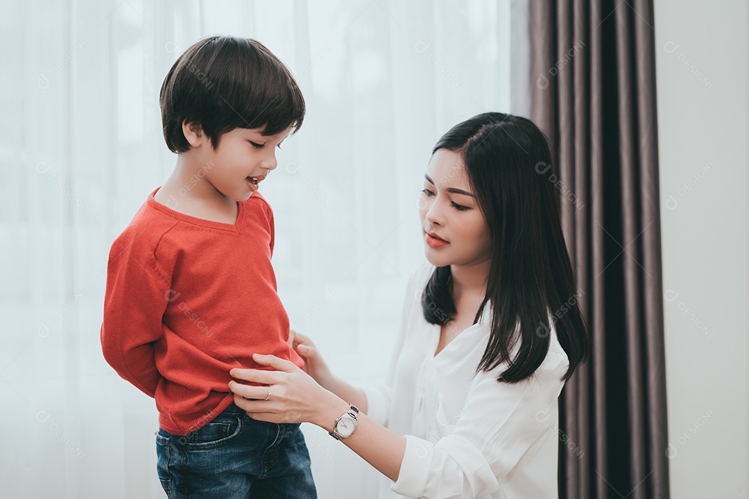 Mãe vestindo um filho para a escola