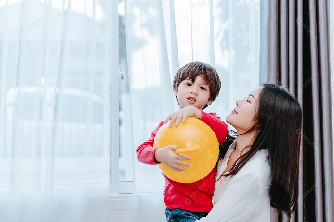 Mãe brincando com o filho de bola pela manhã