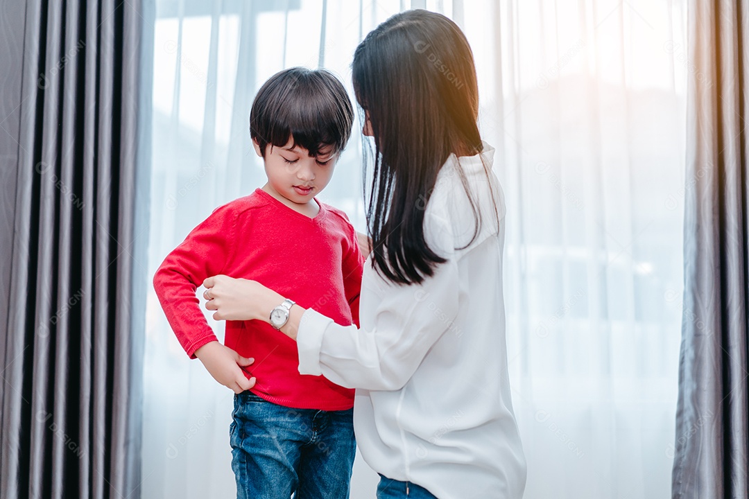 Mãe vestindo um filho para a escola