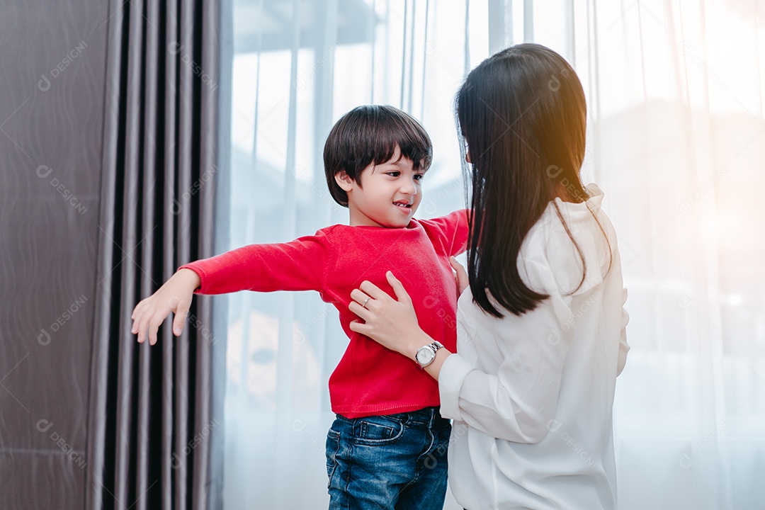 Mãe vestindo um filho para a escola
