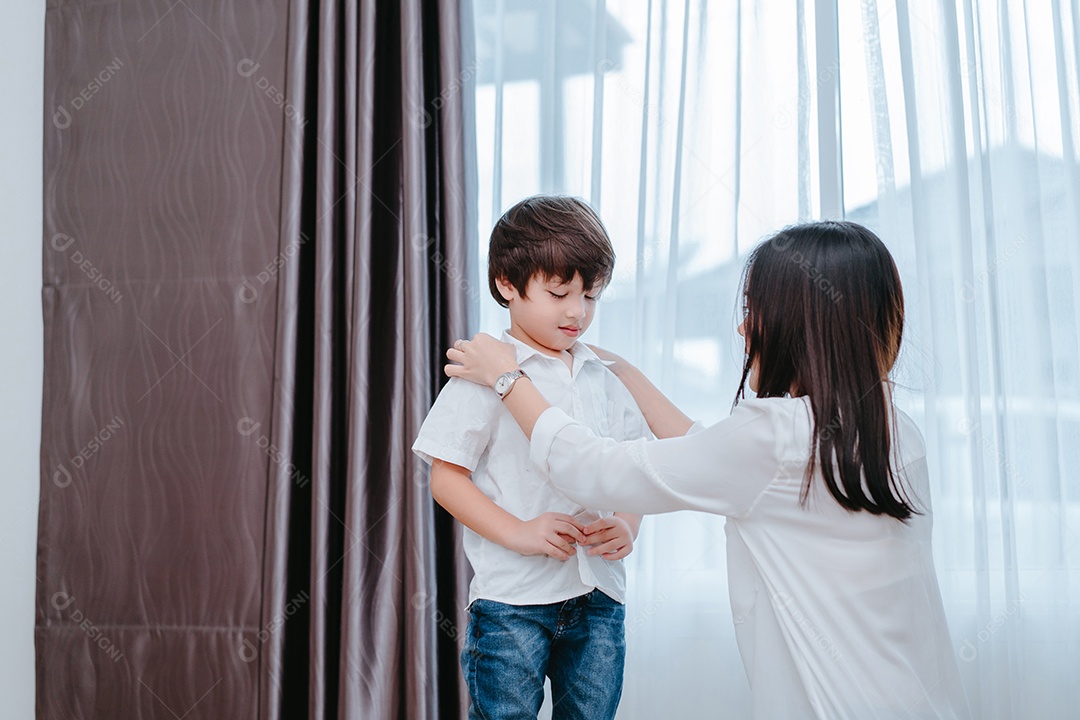 Mãe vestindo um filho para a escola