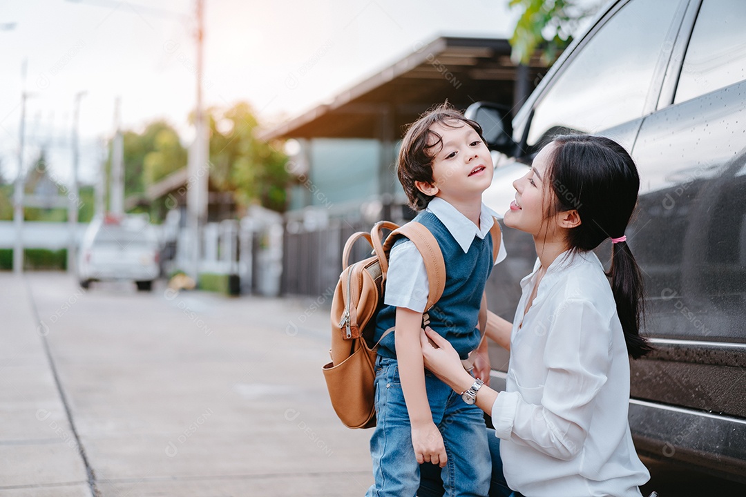 Mãe vestindo um filho e mandando para a escola