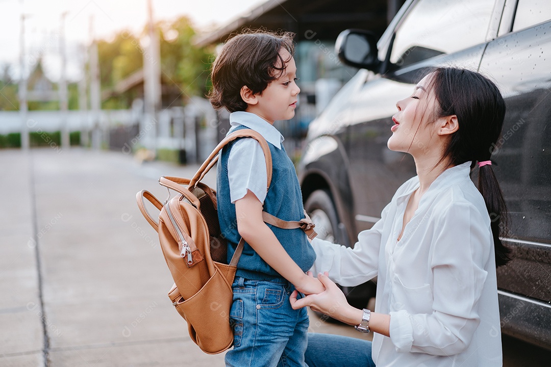 Mãe vestindo um filho e enviando para a escola