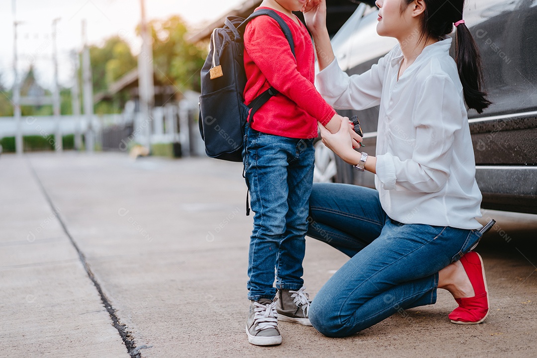 Mãe vestindo um filho e enviando para a escola