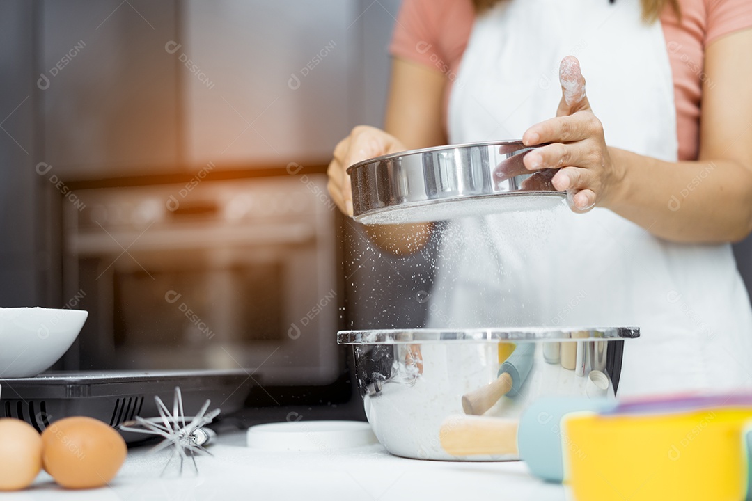 Mulher cozinhando na cozinha quebrando ovo na tigela