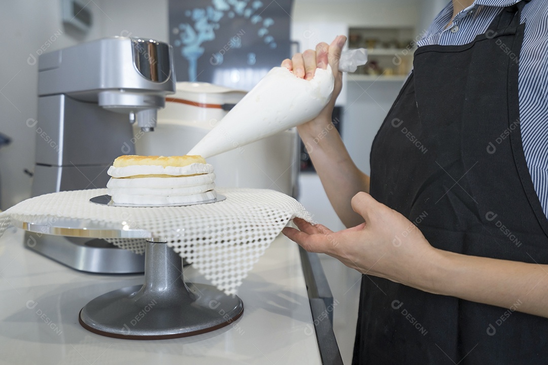 A mulher adicionou chantilly no bolo