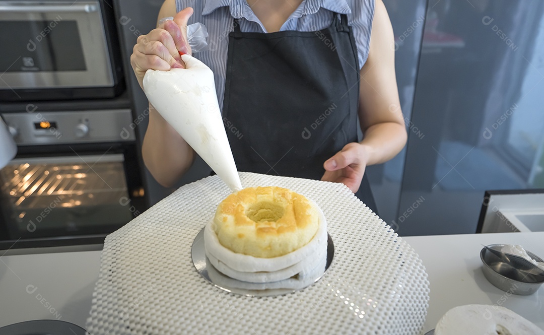 A mulher adicionou chantilly no bolo