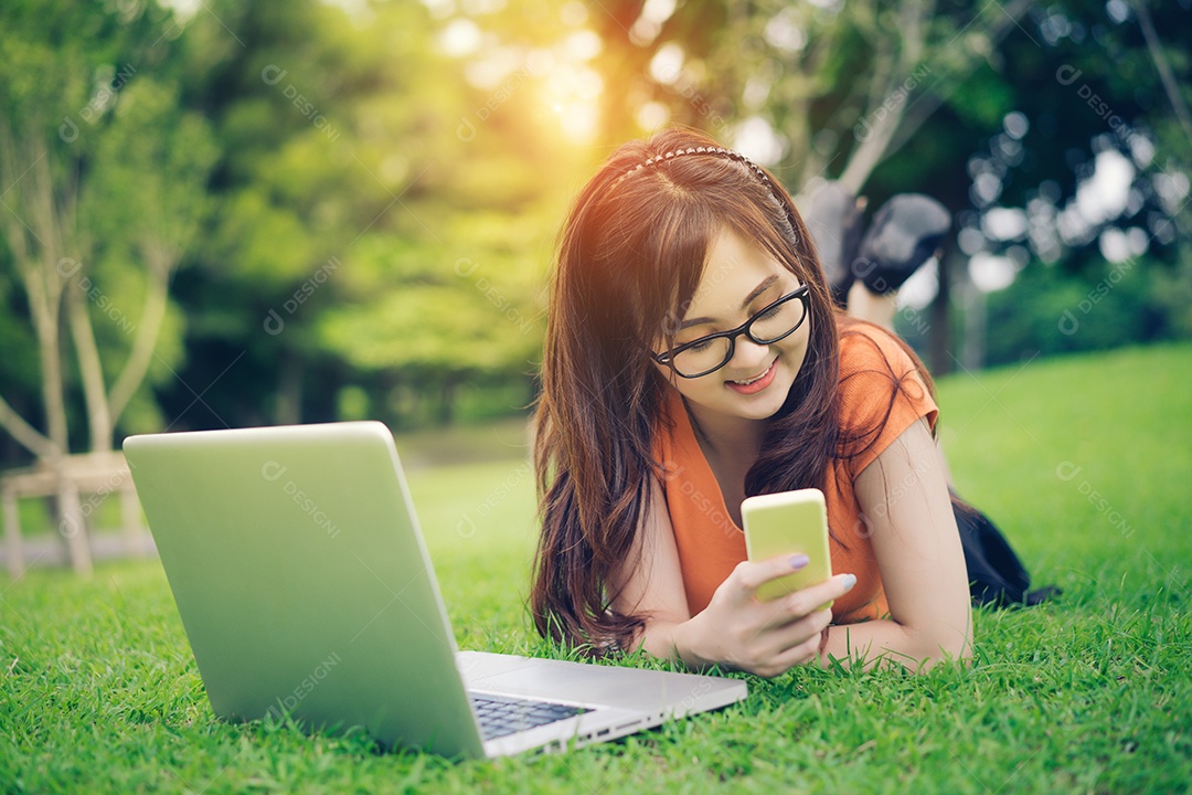 Menina usando smartphone, tablet e laptop conceito on-line de marketing no parque ao ar livre