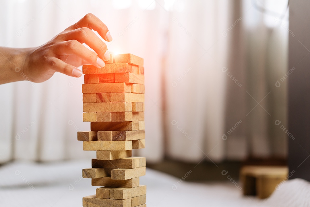 Mão em blocos de madeira na construção de torre