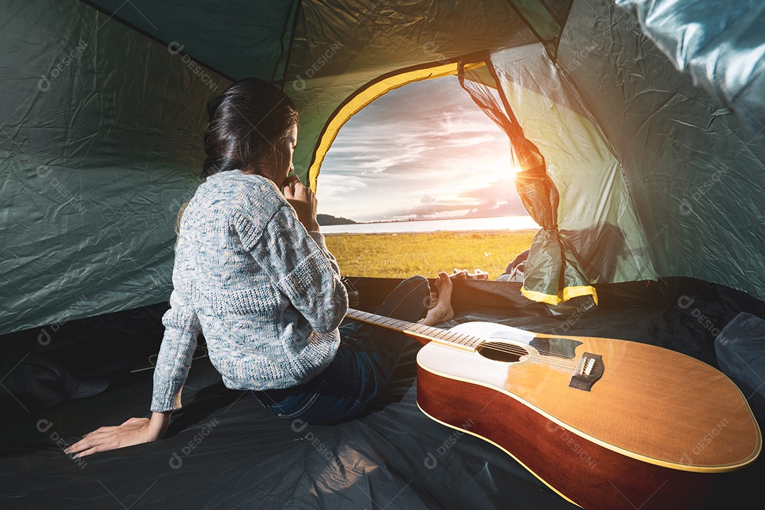 Mulher viajando acampando com violão