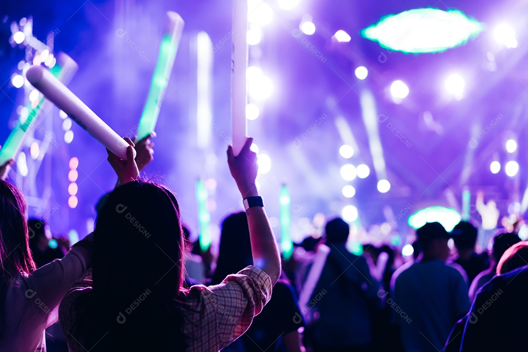 Multidão de mãos levantando as luzes do palco do concerto e a silhueta do público de fãs de pessoas