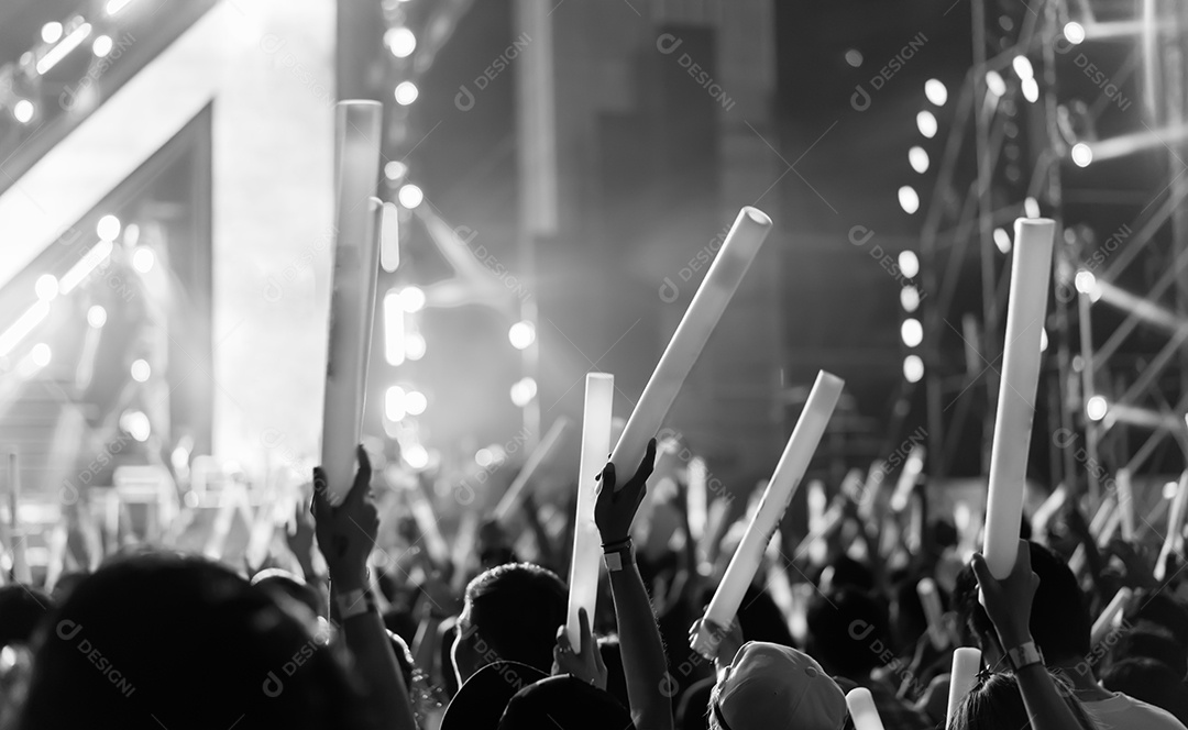 Multidão de mãos levantando as luzes do palco do concerto e a silhueta do público de fãs de pessoas