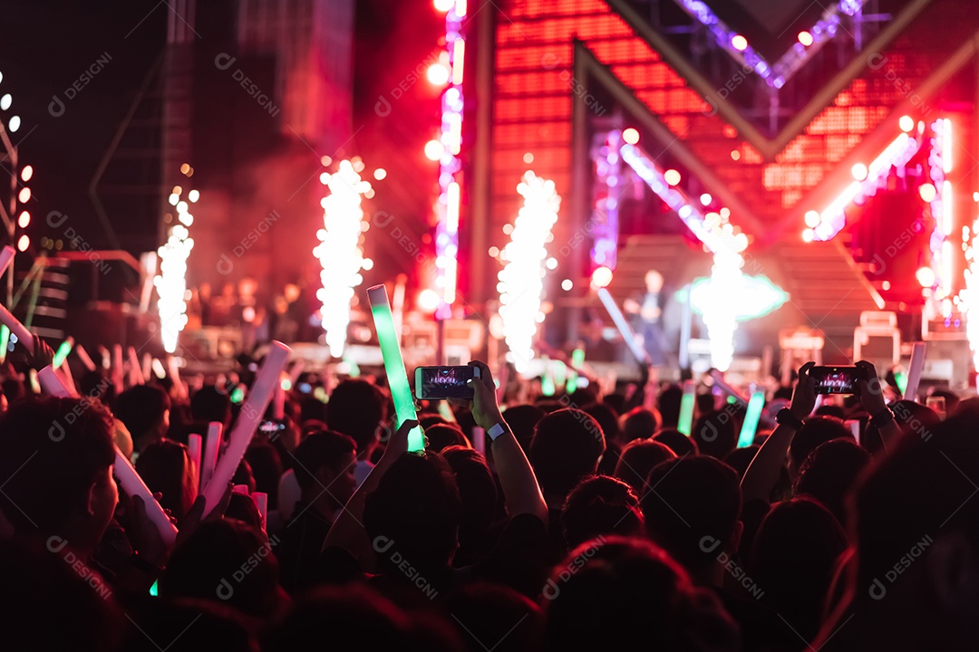 Multidão de mãos levantando as luzes do palco do concerto e a silhueta do público de fãs de pessoas