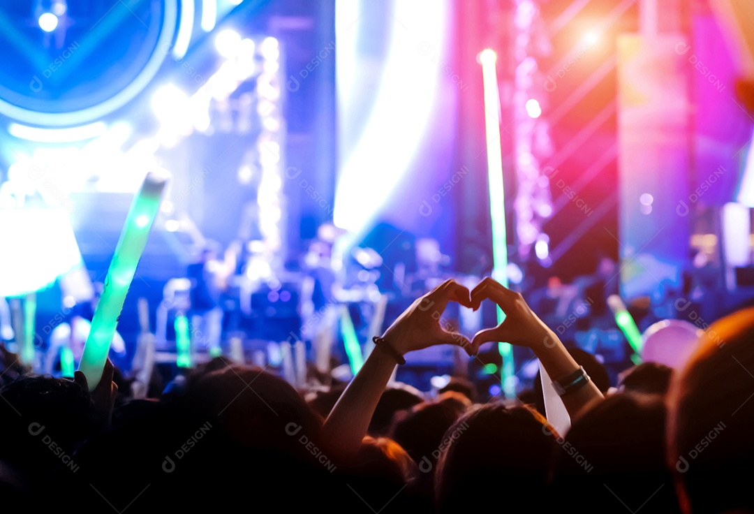 Multidão de mãos levantando as luzes do palco do concerto e a silhueta do público de fãs de pessoas