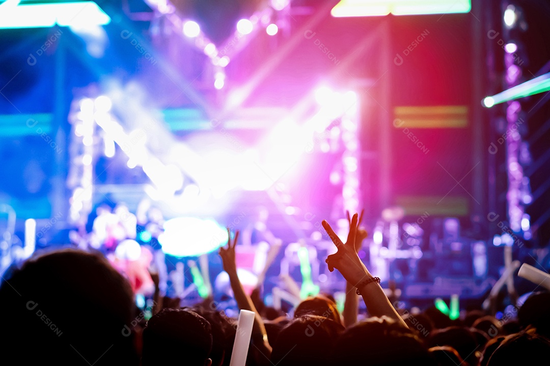 Multidão de mãos levantando as luzes do palco do concerto e a silhueta do público de fãs de pessoas