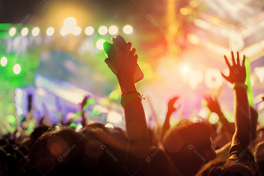 Multidão de luzes do palco de concertos e silhueta de público de fãs de pessoas levantando as mãos ou bastão luminoso