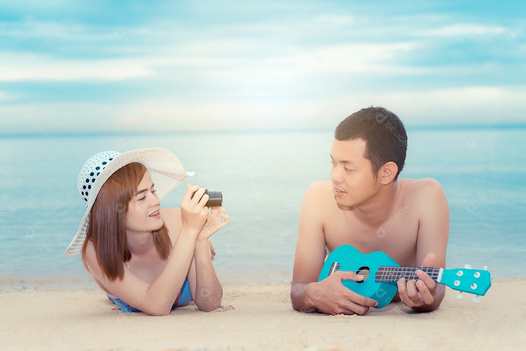 Jovem com chapéu tirando foto namorado tocando ukulele sorriso feliz casal lua de mel romântica
