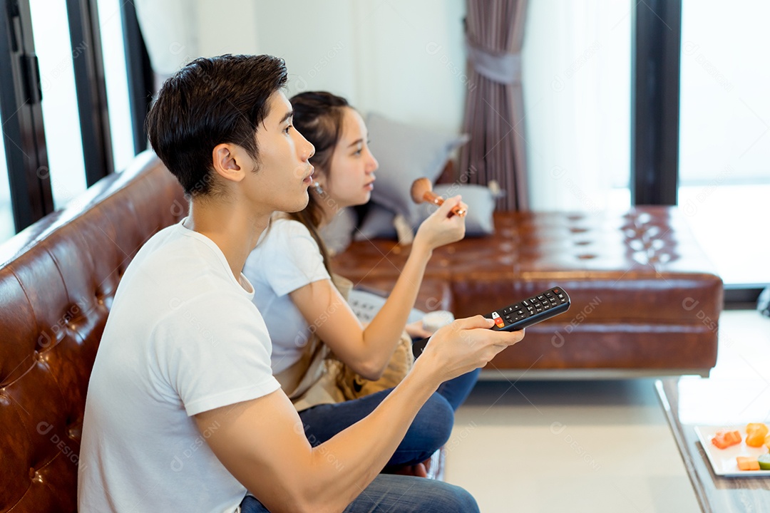 Casal juntos assistindo televisão reação séria no sofá