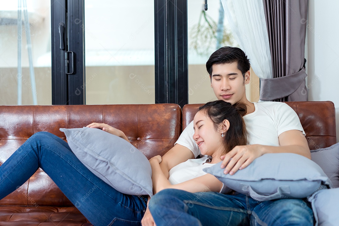 Casal asiático dormindo juntos no sofá relaxando