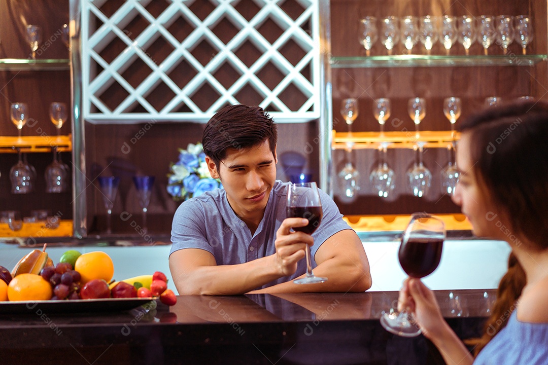 Jovem casal asiático juntos, homem e mulher brindam taças de vinho