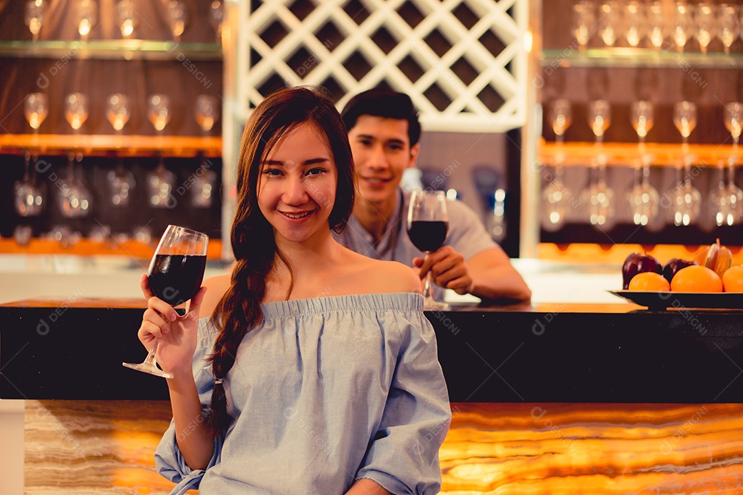 Jovem casal asiático juntos, homem e mulher brindam taças de vinho