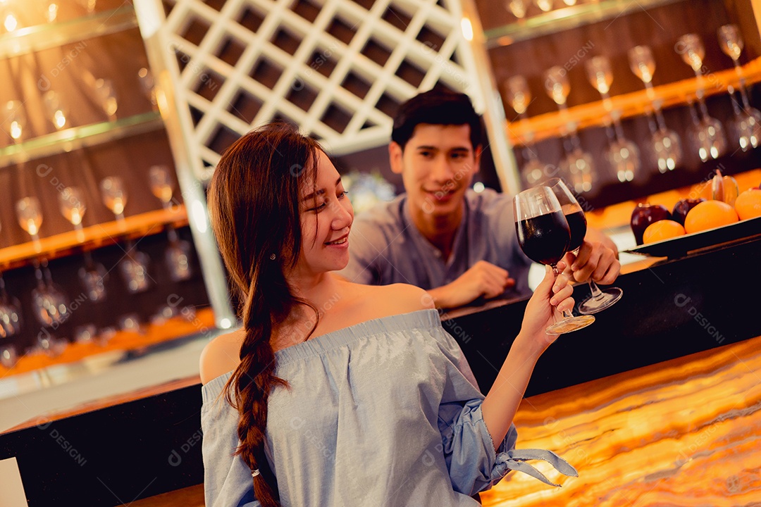 Jovem casal asiático juntos, homem e mulher brindam taças de vinho