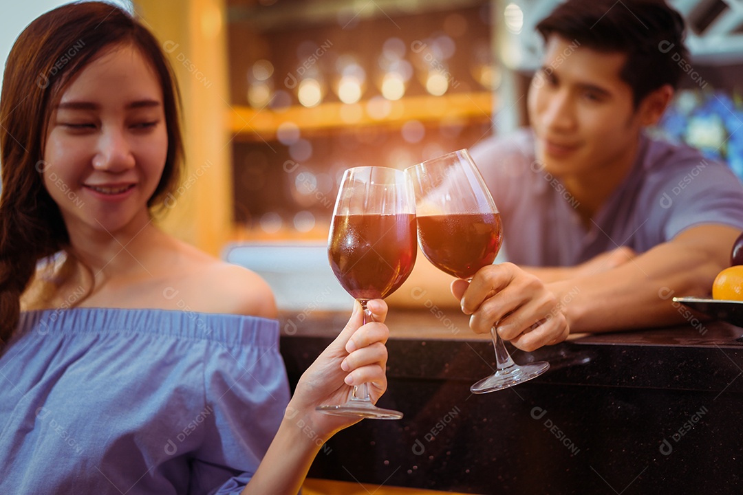 Jovem casal asiático juntos, homem e mulher brindam copos de vinho