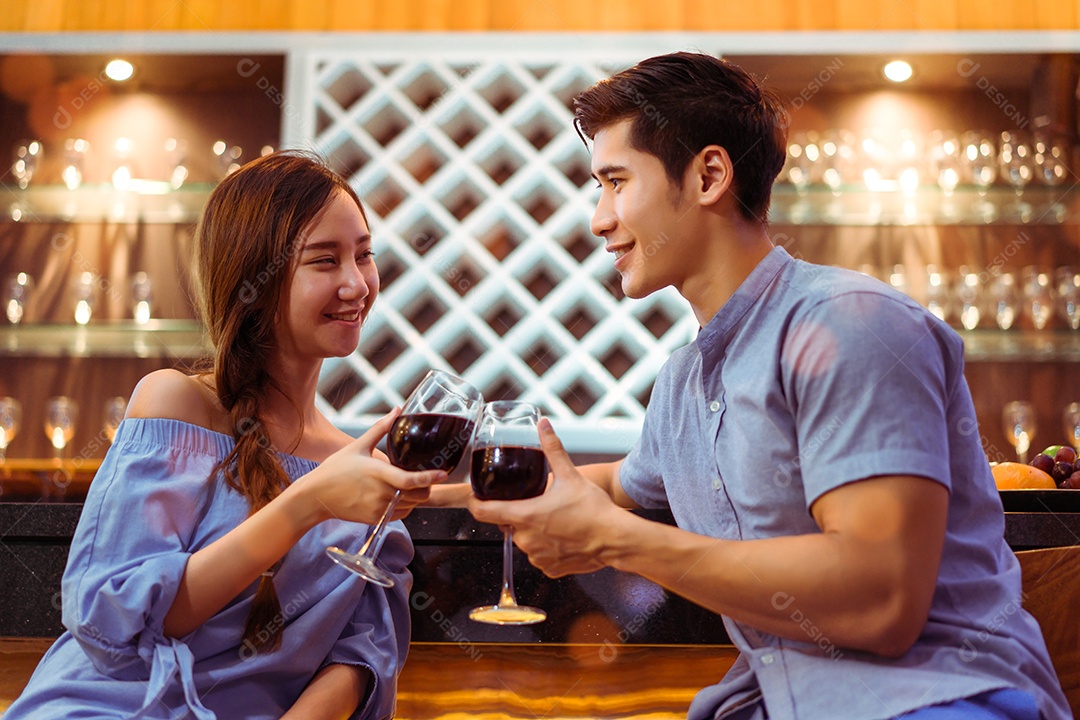 Jovem casal asiático juntos, homem e mulher brindam copos de vinho