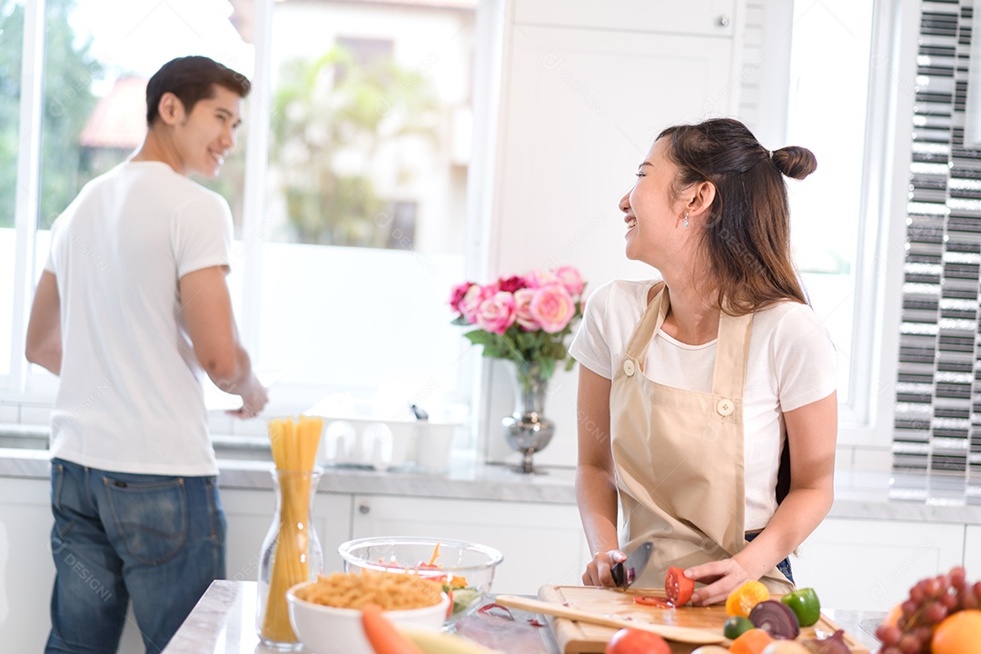 Casal cozinhando comida na cozinha fazendo jantar
