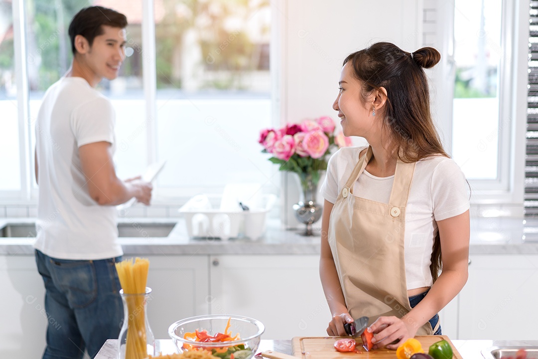 Casal cozinhando comida na cozinha fazendo jantar