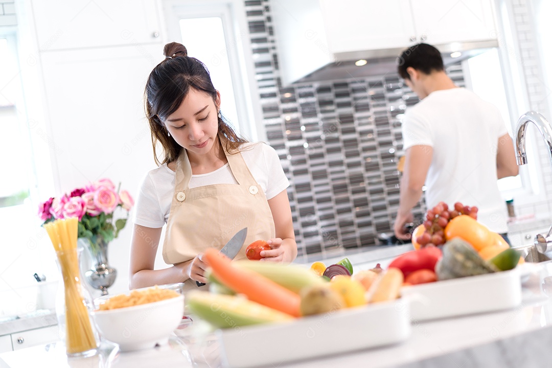 Casal cozinhando comida na cozinha fazendo jantar