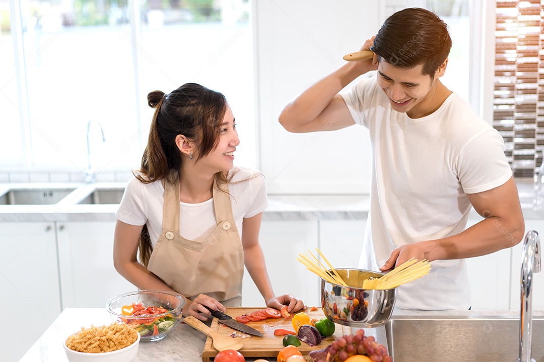 Casal cozinhando comida na cozinha fazendo jantar