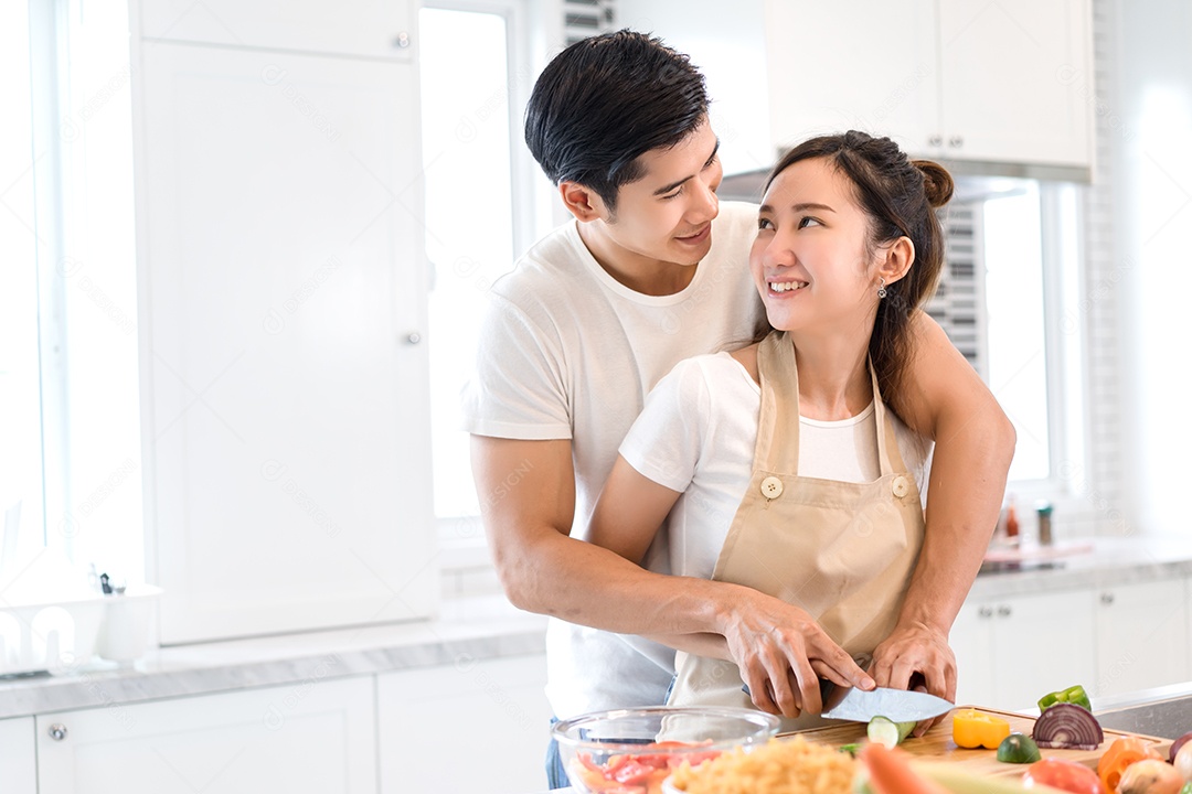 Casal cozinhando comida na cozinha fazendo jantar