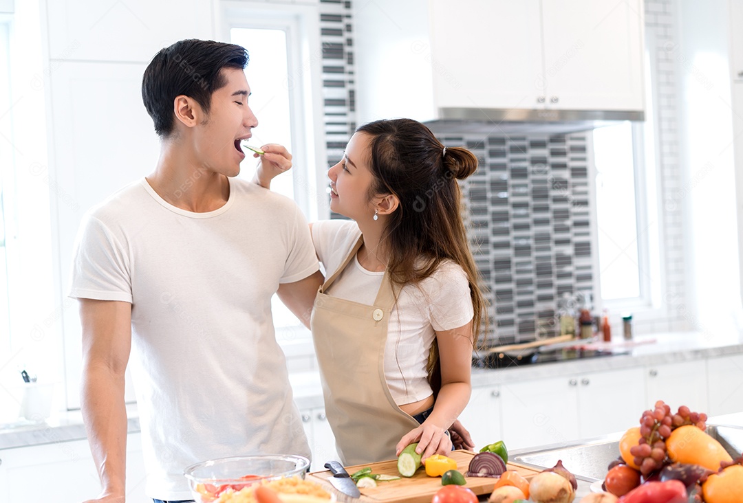 Casal cozinhando comida na cozinha fazendo jantar