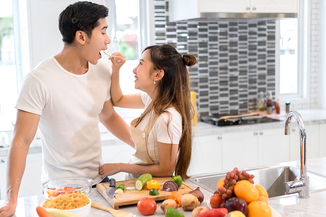 Casal cozinhando comida na cozinha fazendo jantar