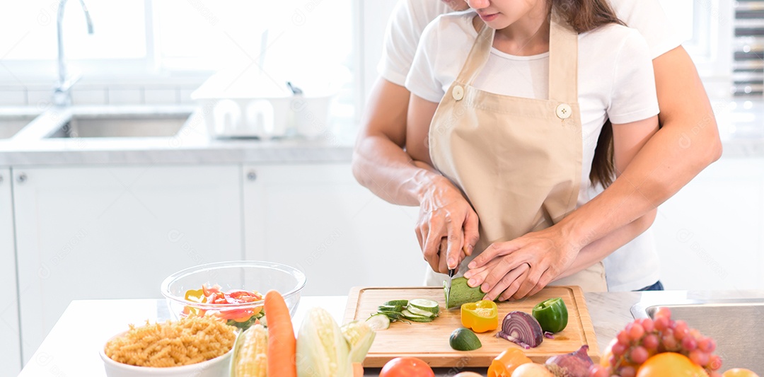 Jovens asiáticos e mulheres se juntam cortando vegetais em fatias