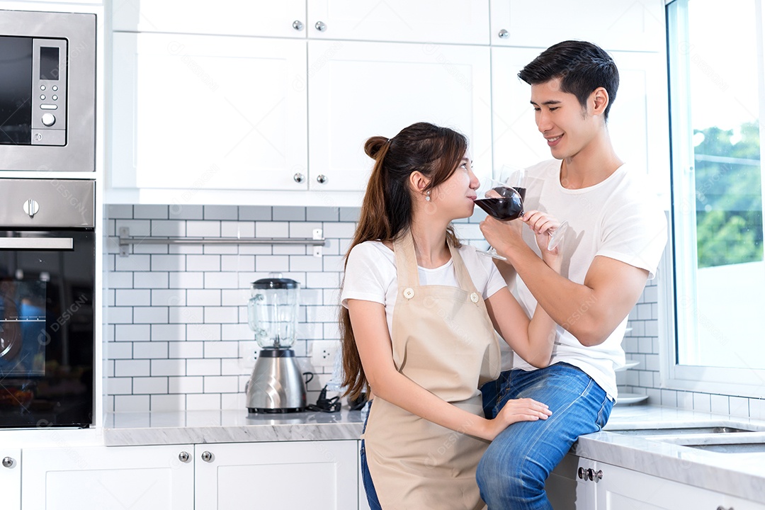 Casal jovem asiáticos segurando copos de vinho bebendo depois do jantar