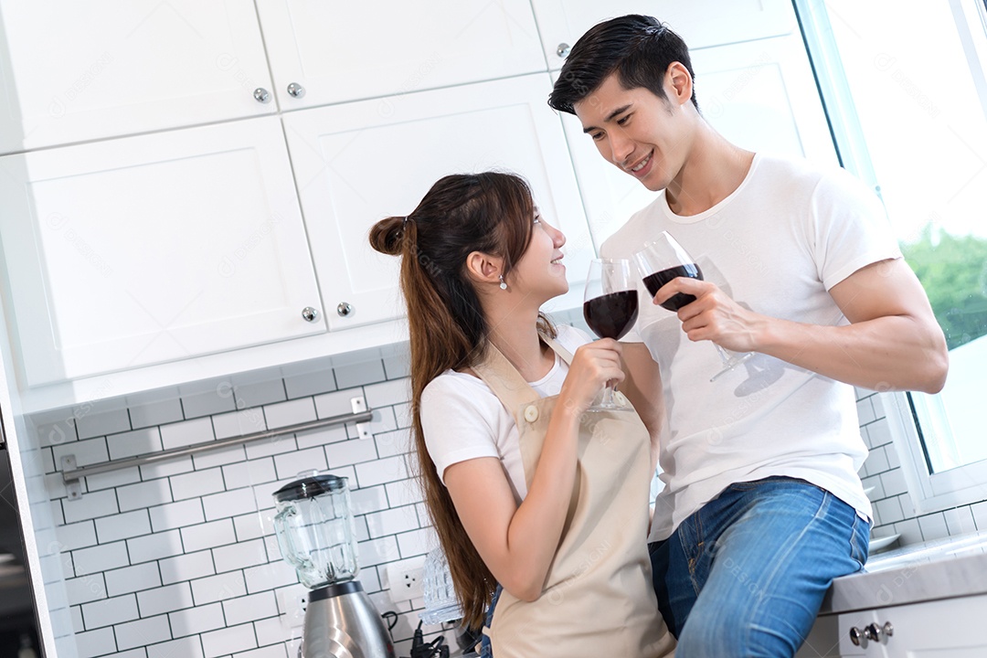 Casal jovem asiáticos segurando copos de vinho bebendo depois do jantar