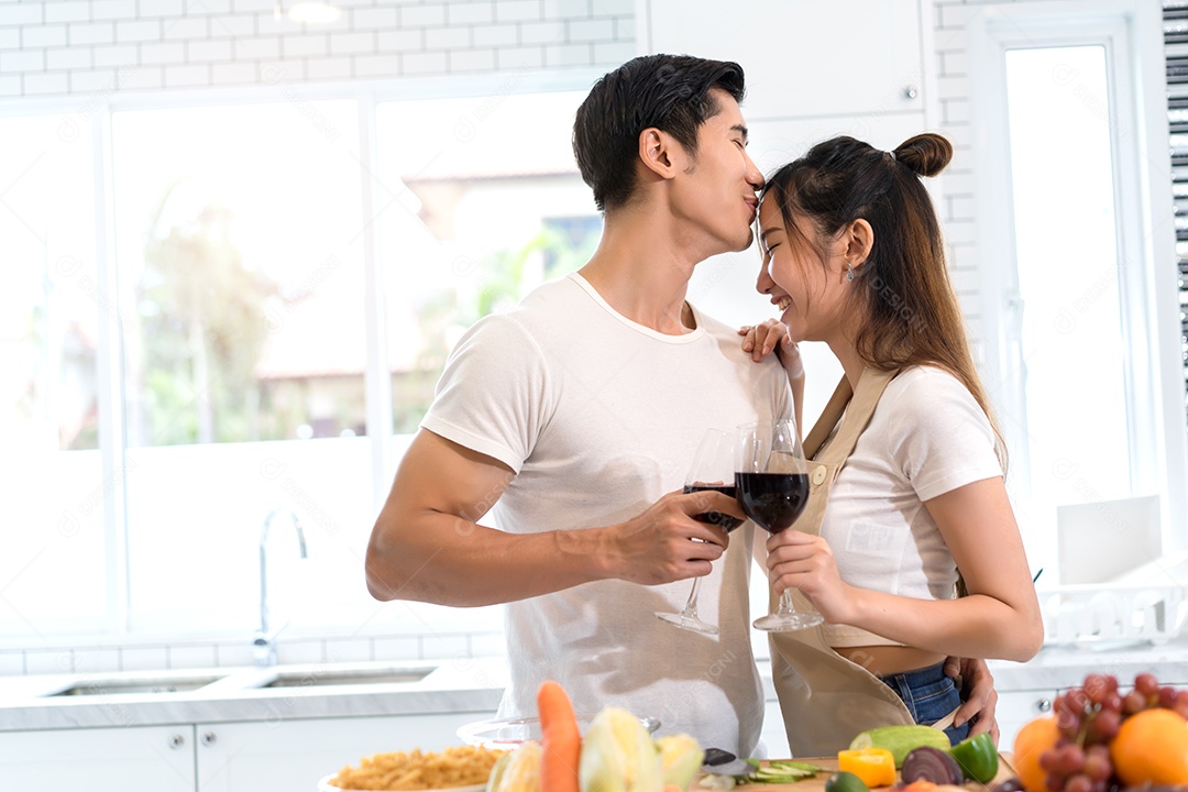 Casal jovem asiáticos segurando copos de vinho bebendo depois do jantar