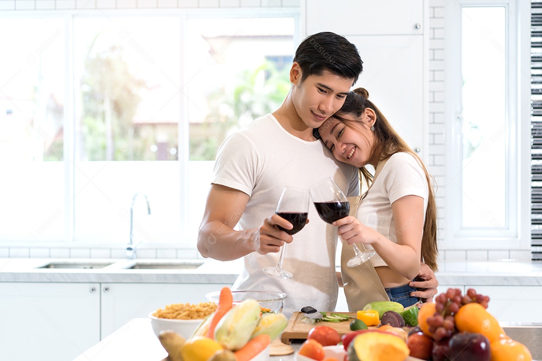 Casal jovem asiáticos segurando copos de vinho bebendo depois do jantar