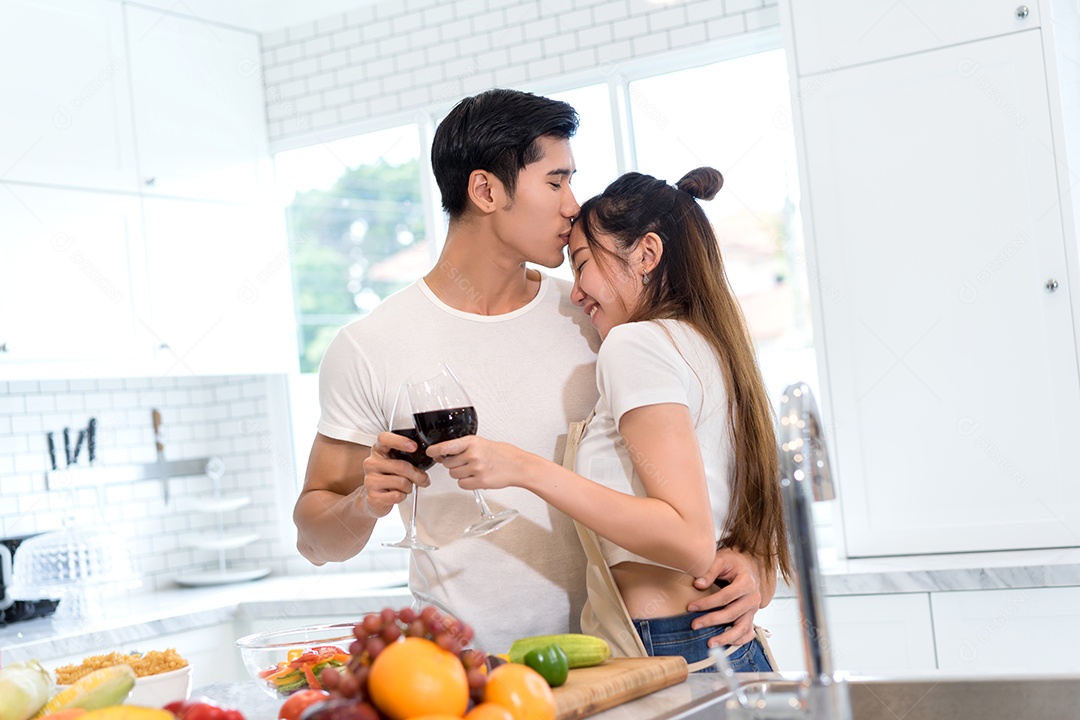 Casal jovem asiáticos segurando copos de vinho bebendo depois do jantar